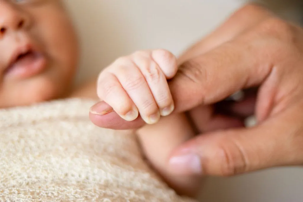 baby holding father photo