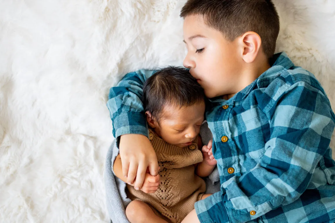 Toddler Hugging a Newborn Baby