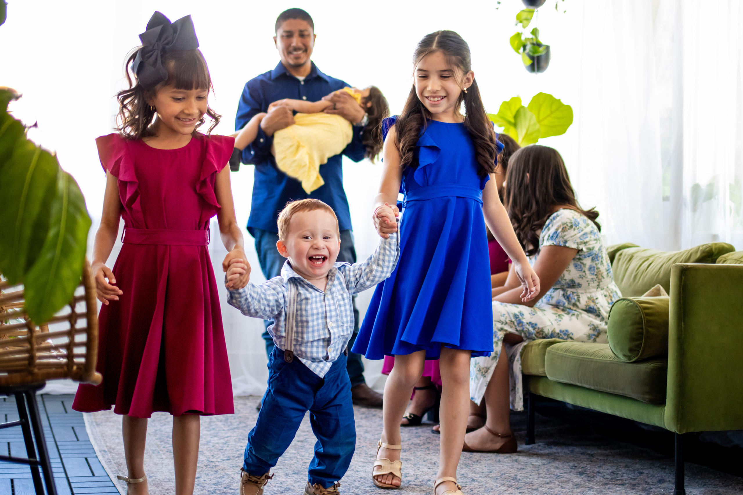 Three Children Holding Each Other and Smiling for a Family Photo