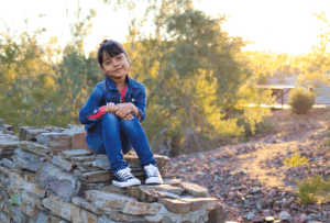 Young Girl Sitting at Big Rock for Photography