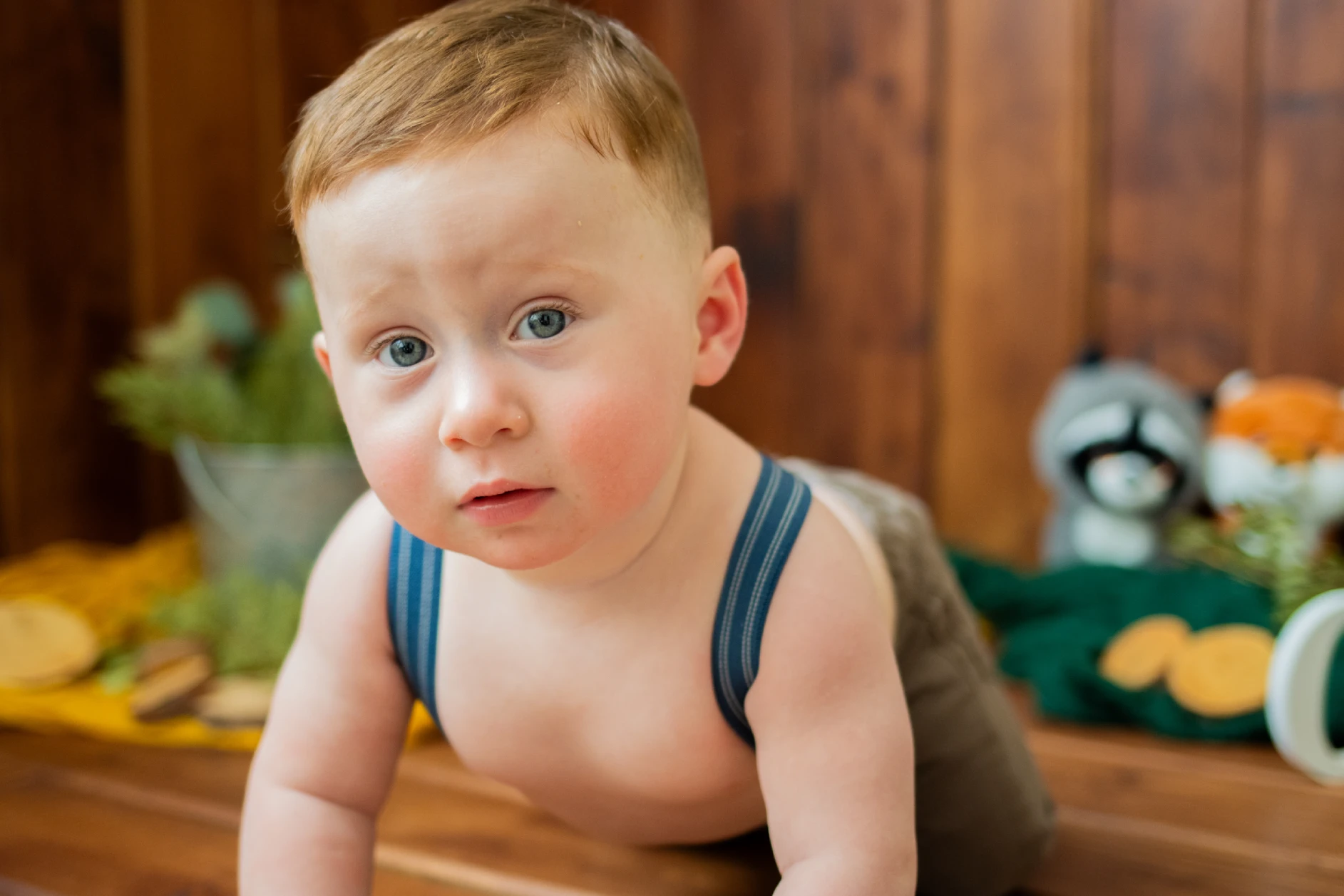 Cake smash theme countryside photoshoot with a rustic setup, natural elements, and a joyful baby enjoying a cake smash.