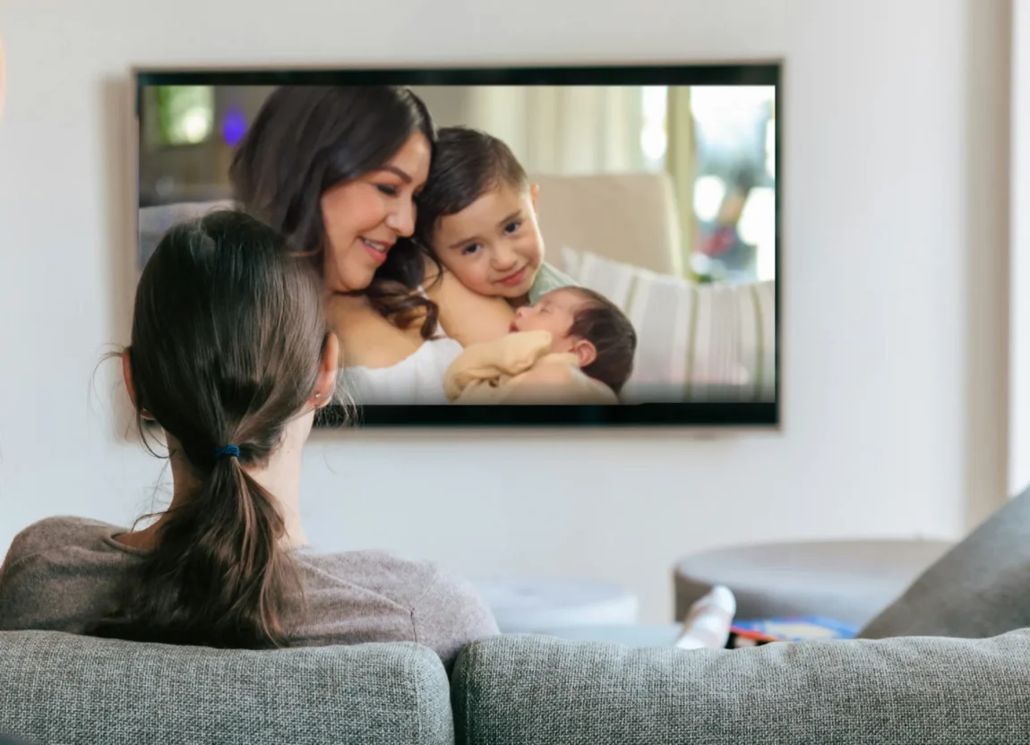 Woman enjoying a family movie night while watching photo slideshow on screen