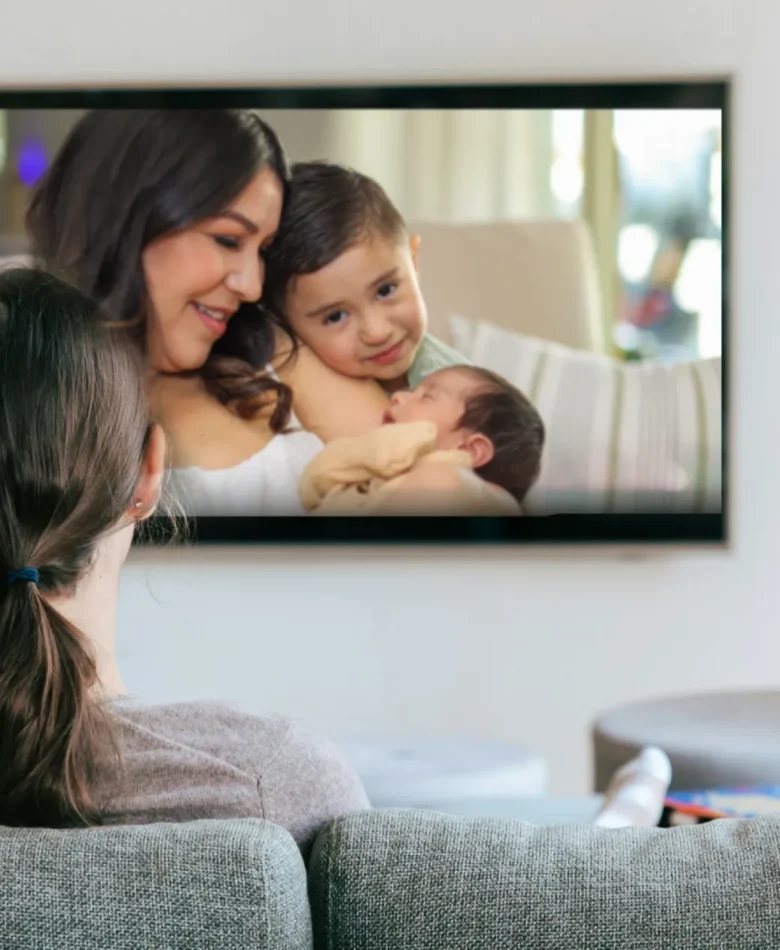 Woman enjoying a family movie night while watching photo slideshow on screen