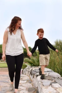 Mom and son walking together laughing outdoors showing how a mom is balancing photography business and mom life