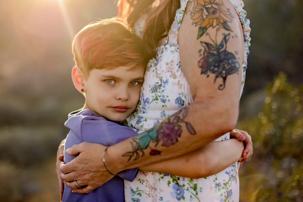 A child resting their face against their mother's side in a close embrace during a Mother's Day family mini session in AZ.