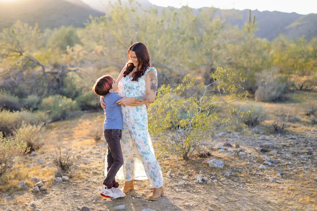 A son hugging his mother in the Arizona desert during golden hour, captured during a Mother's Day family Photos session in AZ.
