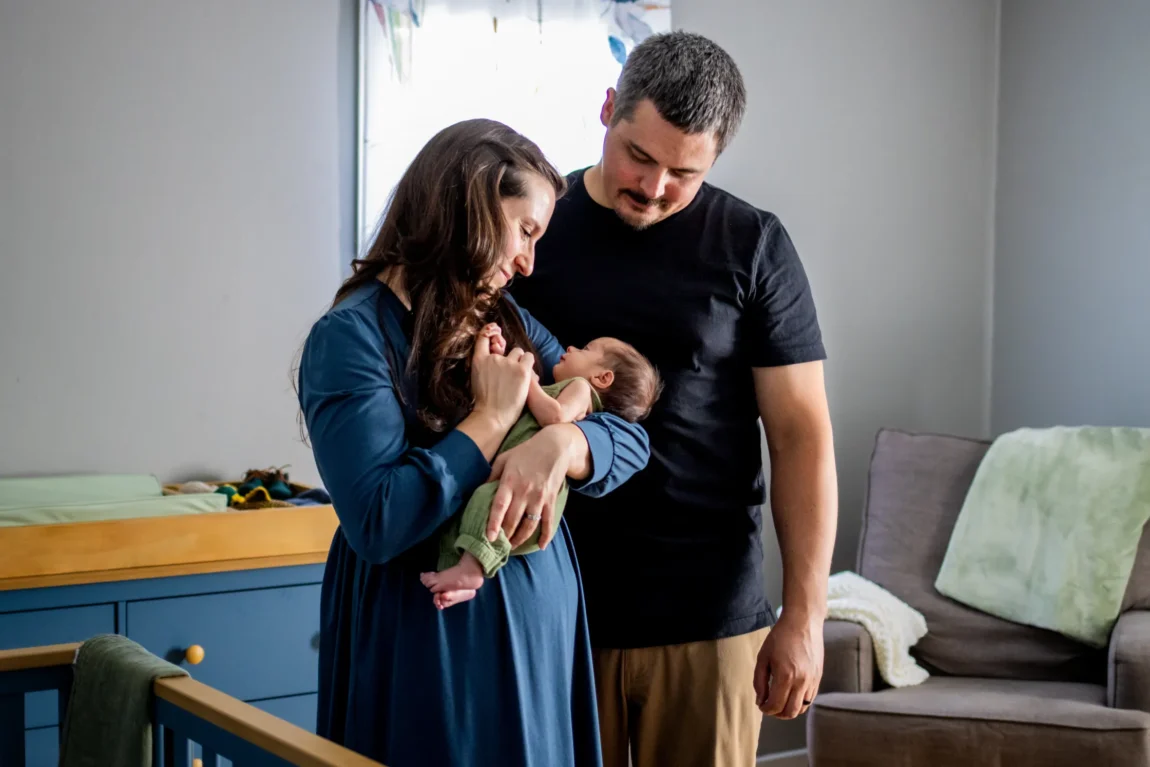 Parents holding their newborn in the nursery during an in-home newborn session in the West Valley