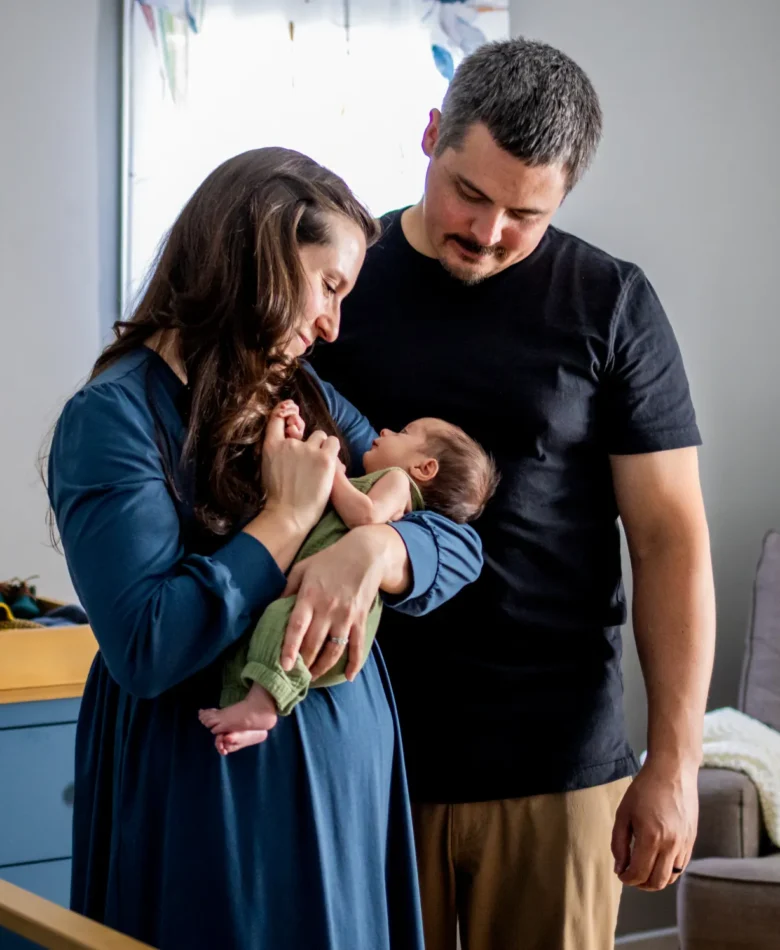 Parents holding their newborn in the nursery during an in-home newborn session in the West Valley
