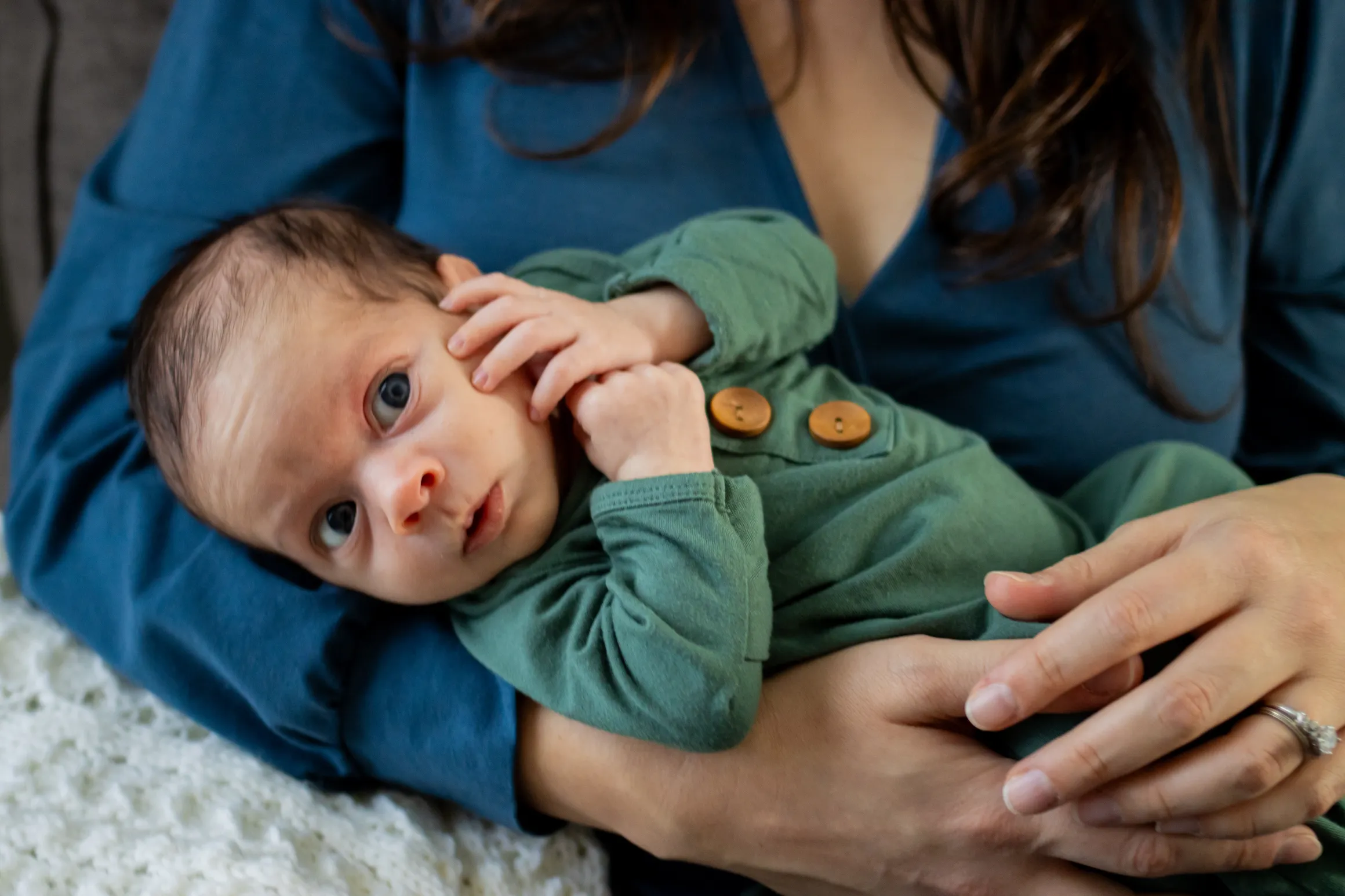 Newborn cradled in mom's arms during an in-home newborn session in the West Valley