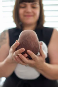 Are newborn photos worth it? This mom cradling her newborn's head says it all