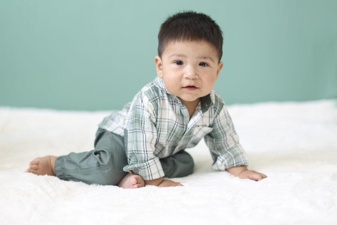 Baby boy crawling on blanket during sitter session photos in Phoenix studio