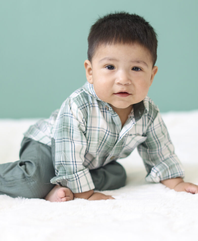 Baby boy crawling on blanket during sitter session photos in Phoenix studio